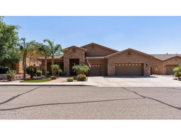 Charming home featuring a three-car garage, desert landscaping, and a stone-accented entry at 27421 N 22Nd Ln, Phoenix, AZ 85085
