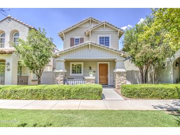 Charming two-story home featuring a welcoming front porch with stone accents and manicured landscaping at 3893 E Gideon Way, Gilbert, AZ 85296