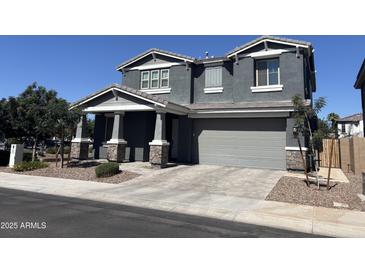Charming two-story home featuring a gray facade, well-manicured landscaping, and an attached two-car garage at 4490 S Montana Dr, Chandler, AZ 85248