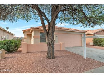 Charming single-story home with a desert landscape, complemented by a two car garage and a welcoming front entrance at 6434 W Riva Rd, Phoenix, AZ 85043