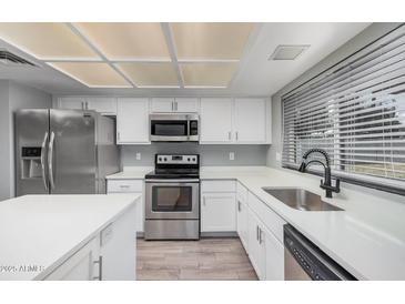 Modern kitchen featuring stainless steel appliances, white cabinets, and a sleek design, perfect for cooking and entertaining at 17201 N 35Th Dr, Glendale, AZ 85308