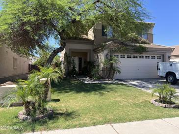 Charming two-story home with desert landscaping, mature shade trees and a two car garage at 21873 W Pima St, Buckeye, AZ 85326
