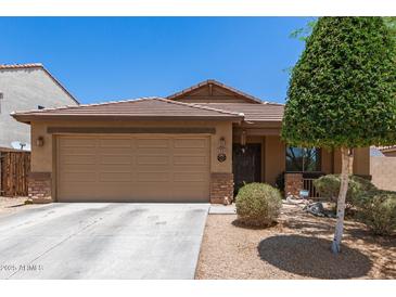 Charming single-story home featuring a two-car garage and desert landscaping at 2223 S Hughes Dr, Buckeye, AZ 85326