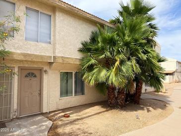 Charming townhome with desert landscaping, featuring mature palm trees for added curb appeal at 3840 N 43Rd Ave # 34, Phoenix, AZ 85031