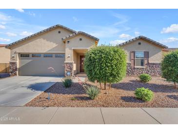 Charming single-story home featuring a two-car garage and desert landscaping at 40657 W Somers Dr, Maricopa, AZ 85138