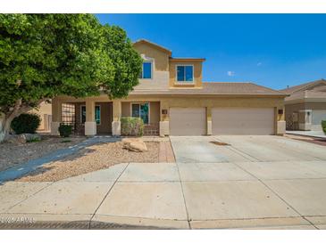 Inviting two-story home with a two-car garage, desert landscaping, and charming front porch at 12950 W Alegre Dr, Litchfield Park, AZ 85340