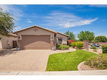 Inviting single-story home featuring a well-manicured lawn, paver driveway, and an attached two-car garage at 1410 W Popcorn Tree Ave, Queen Creek, AZ 85140