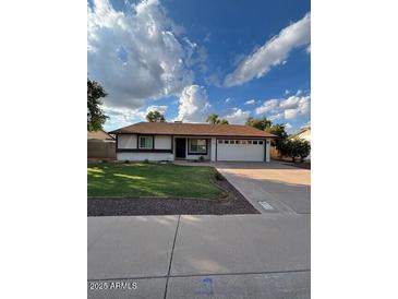 Charming single-story home featuring a well-manicured lawn and a two-car garage at 1616 W Temple St, Chandler, AZ 85224