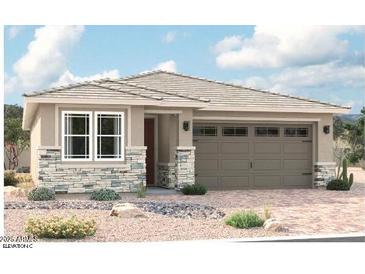 Charming single-story home featuring stone accents, neutral color palette, and a two-car garage at 16974 W Winston Dr, Goodyear, AZ 85338