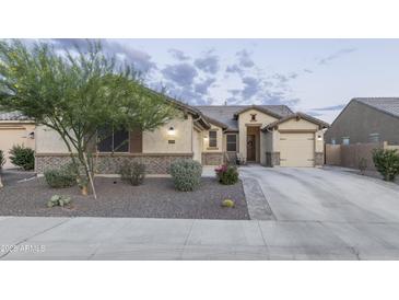 Charming single-story home with a well-manicured lawn and a two-car garage at 18493 W Hiddenview Dr, Goodyear, AZ 85338