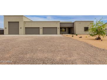 Contemporary home featuring a three car garage, desert landscaping, and neutral color palette at 2516 W Joy Ranch Rd, Phoenix, AZ 85086