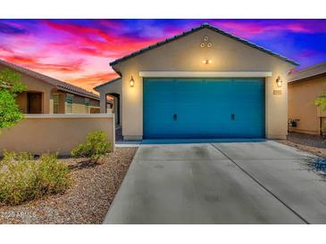 Charming single-story home with a two-car garage and a colorful blue door at 39985 W Rio Lobo Dr, Maricopa, AZ 85138