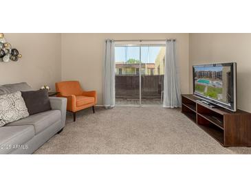 Bright living room with comfortable seating and sliding glass doors to balcony at 461 W Holmes Ave # 360, Mesa, AZ 85210