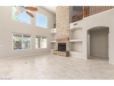 Open-concept living room showcasing a stone fireplace and large windows at 4801 E Quien Sabe Way, Cave Creek, AZ 85331