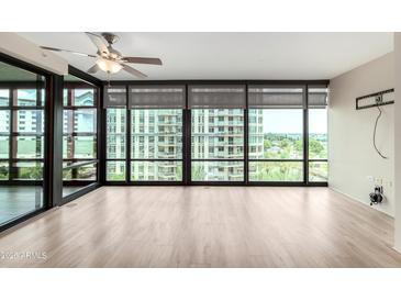 Bright living room with lots of natural light from the floor to ceiling windows, plus a ceiling fan at 4808 N 24Th St # 702, Phoenix, AZ 85016
