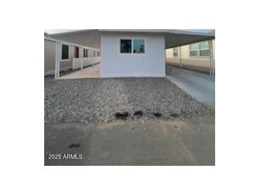 This property features a covered parking area, gravel landscaping, and a clean, modern exterior at 500 N 67 Ave # 149, Phoenix, AZ 85043