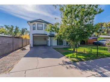Two-story home features an attached carport, a well-maintained lawn, and mature landscaping at 505 W Howe St, Tempe, AZ 85281