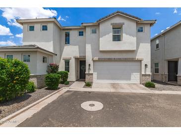 Charming white two-story home featuring an attached two-car garage and beautiful front yard landscaping at 5460 S Dillon Cir, Mesa, AZ 85212