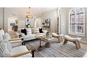 Bright living room with neutral tones, stylish furniture, and modern decor with light coming in from window shutters at 7955 E Chaparral Rd # 115, Scottsdale, AZ 85250