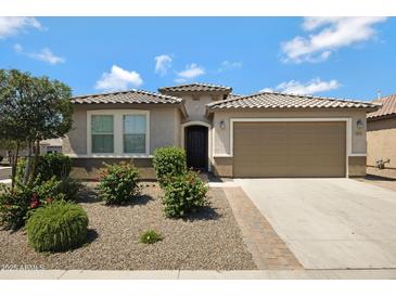 Charming single-story home featuring a desert landscape, a two-car garage, and a stylish tiled roof at 25974 W Horsham Dr, Buckeye, AZ 85396