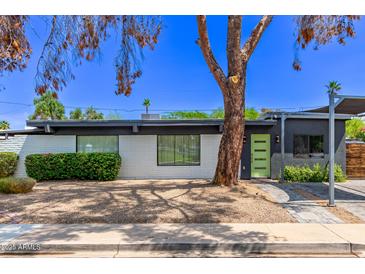 Contemporary home featuring a white brick facade, green door, and professionally landscaped front yard at 3710 E Altadena Ave, Phoenix, AZ 85028