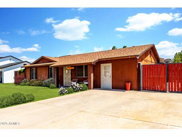 Charming single-story home features a well-maintained front yard with lush green grass and a spacious driveway at 3723 W Columbine Dr, Phoenix, AZ 85029
