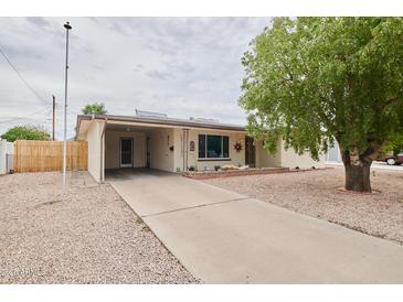 Charming single-story home featuring a covered carport and a well-maintained gravel front yard at 5410 E University Dr, Mesa, AZ 85205