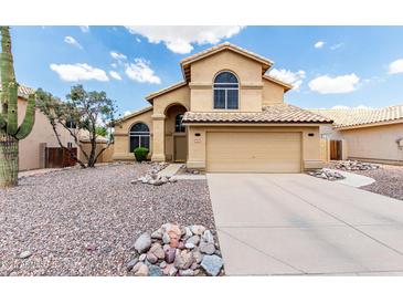 Inviting two-story home with a neutral stucco exterior, rock landscaping, and a tile roof for a stylish look at 6516 E Rochelle St, Mesa, AZ 85215