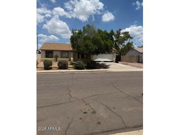 Cozy single-story home with a well-maintained lawn and a two car garage at 8008 E Cicero St, Mesa, AZ 85207