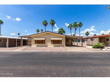 Charming single-story home featuring a covered carport and desert landscaping at 9302 E Broadway Rd # 45, Mesa, AZ 85208