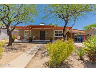 Charming single-story home featuring desert landscaping and a covered front porch with cozy seating at 9603 N 1St Ave, Phoenix, AZ 85021