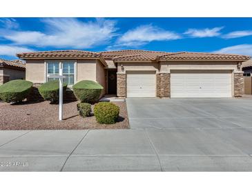 Charming single-story home featuring a three-car garage and well-manicured landscaping at 9952 W Jessie Ln, Peoria, AZ 85383