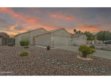 Charming single-story home with a well-manicured, low-maintenance rock front yard and a two-car garage at 15470 W Mauna Loa Ln, Surprise, AZ 85379