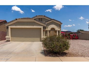 Charming single-story home features a two car garage and inviting curb appeal with desert landscaping and a blue sky backdrop at 1680 E Cardinal Dr, Casa Grande, AZ 85122