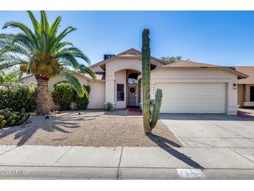Inviting single-story home with desert landscaping, mature palm tree, and private two-car garage at 4443 W Escuda Dr, Glendale, AZ 85308
