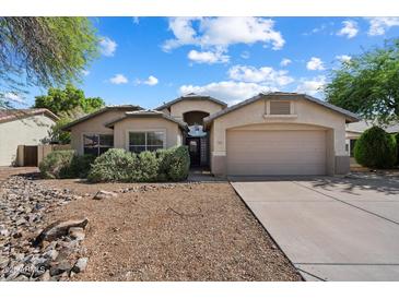 Inviting single-story home featuring an attached two-car garage and desert-style landscaping at 7925 E Osage Ave, Mesa, AZ 85212