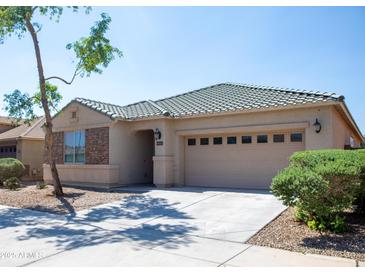 Inviting single-story home featuring a two-car garage, stone accents, and landscaped front yard at 9025 W Crown King Rd, Tolleson, AZ 85353