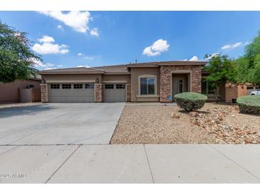 Beautiful single-Gathering home with stone accents and a spacious three-car garage on a sunny day at 15088 W Coolidge St, Goodyear, AZ 85395