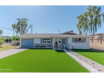 Charming single-story home with manicured lawn, blue shutters, and inviting entrance at 1749 E Medlock Dr, Phoenix, AZ 85016