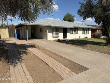 Charming single-story home featuring a brick driveway and front yard with mature landscaping and a covered front porch at 3001 N 21St Ave, Phoenix, AZ 85015