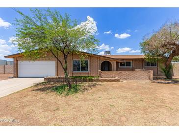 Charming single-story brick home with a well-maintained front yard and a convenient two-car garage at 4556 W Cholla St, Glendale, AZ 85304