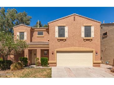 Inviting two-story home featuring a two-car garage and a cozy front porch, enhanced by desert landscaping at 7029 S Golfside Ln, Phoenix, AZ 85042