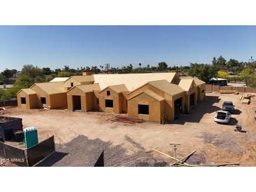 Expansive single-story home under construction with visible framework and spacious layout in a sunny, desert landscape setting at 7620 E Paradise Dr, Scottsdale, AZ 85260