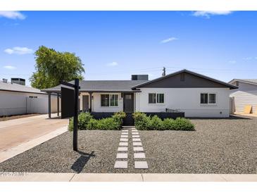 Charming single-story home with white painted brick, grey trim, and a tidy, xeriscaped front yard at 7707 E Earll Dr, Scottsdale, AZ 85251