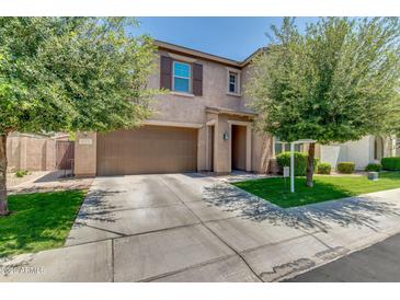 Charming two-story home featuring a two-car garage, well-maintained lawn, and mature trees at 974 W Zion Way, Chandler, AZ 85248