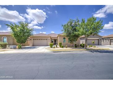 Charming single-story home featuring a tile roof, landscaped front yard, and two-car garage at 9845 E Thistle Ave, Mesa, AZ 85212