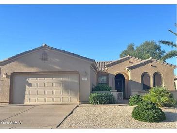Charming single-story home featuring a tile roof, arched windows, desert landscaping, and a two-car garage at 16412 W Peppertree Ct, Surprise, AZ 85387