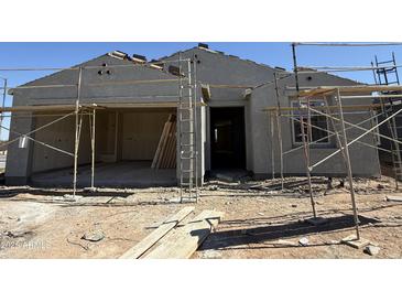 Exterior elevation of a home under construction, with scaffolding and raw materials visible, offering a glimpse of the building process at 9531 W Parkway Dr, Tolleson, AZ 85353