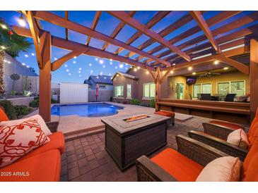 Inviting backyard with a pool, fire pit, pergola, and ample seating for relaxing and entertaining at 10746 W Desert Elm Ln, Peoria, AZ 85383