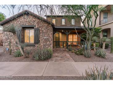 Charming stone-clad home with a cozy front porch and well-manicured desert landscaping at 17728 N 92Nd Pl, Scottsdale, AZ 85255